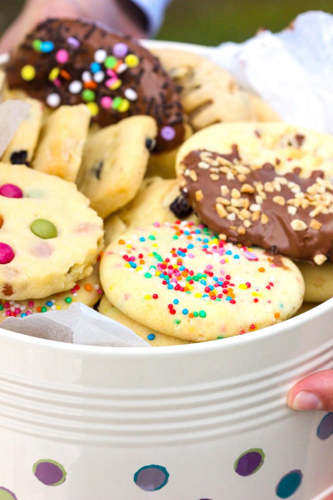 Butter Cookies served in a cake tin with a glass of milk.